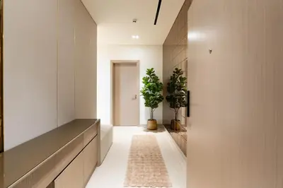 a hallway with white walls and a hallway with potted plants at Designer Apartment 34-56 with Private Jacuzzi in JVC in Dubai