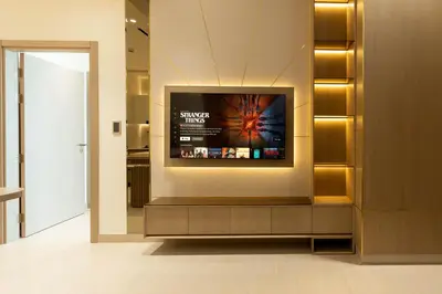 a television on a wall in a room at Designer Apartment 34-56 with Private Jacuzzi in JVC in Dubai