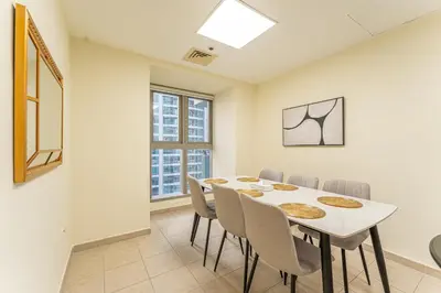 a dining room with a white table and chairs at HAVN - High Floor 2 Bedroom in Marina, near Tram in Dubai