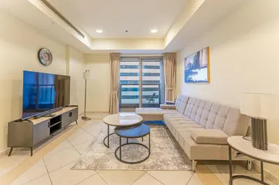 a living room with a couch and a tv at HAVN - High Floor 2 Bedroom in Marina, near Tram in Dubai