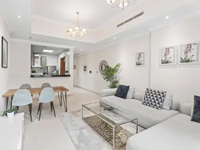 a living room with a couch and a table at Urban Elegance 1BDR in Dunya 06 in Dubai