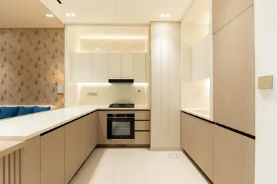 a kitchen with white cabinets and a stove top oven at The Royal Blue Jacuzzi Suite 32 1-6-10 I JVC I Dar Oasis in Dubai