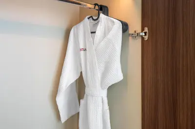 a white robe is hanging on a towel rack at Downtown Dubai - Bright 1BR Apartment - Imperial Avenue in Dubai