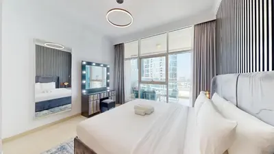 a bedroom with a large bed and a large window at Vacationer l Cozy 1 Bed l Partial Sea View l Prime Location in Dubai