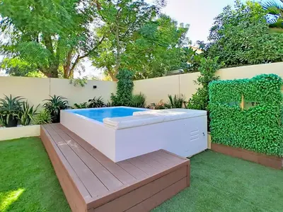 a hot tub sitting on a deck in a garden at Vacationer l Opulent 2 Bedroom Villa l Private Plunge Pool in Dubai
