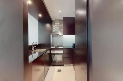 a kitchen with stainless steel appliances and brown cabinets at Vacationer I Premium 2 Bedroom Apartment I Iconic Burj Khalifa View I Downtown I Distinction Tower in Dubai