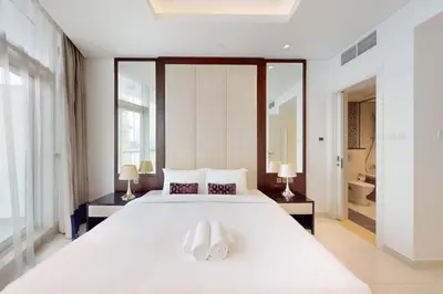 a bedroom with a large white bed with two white shoes at Vacationer I Premium 2 Bedroom Apartment I Iconic Burj Khalifa View I Downtown I Distinction Tower in Dubai