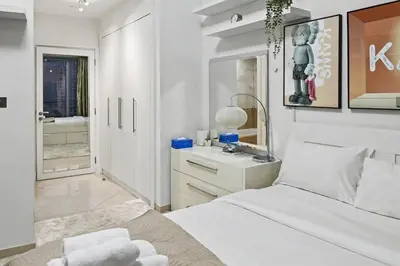 a white bedroom with a bed and a sink at Ultra-Luxury 3BR -Full Sea & Marina Views - JBR in Dubai