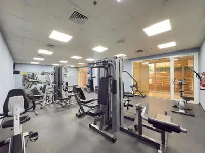 a gym with rows of treadmills and machines at Spacious 1BR Magnolia 1 JVC in Dubai