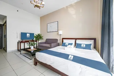 a bedroom with a bed and a living room at Amazing Studio Glitz 1 Dubai Studio city in Dubai