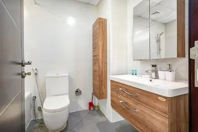 a bathroom with a toilet and a sink and a mirror at Amazing Studio Glitz 1 Dubai Studio city in Dubai