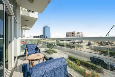 a balcony with blue chairs and a view of a city at Amazing Studio Glitz 1 Dubai Studio city in Dubai