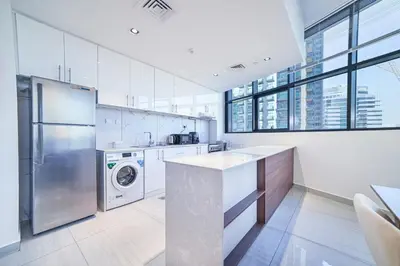 a large kitchen with a washer and dryer in it at Balcony Breeze O2 with amazing high way view in Dubai