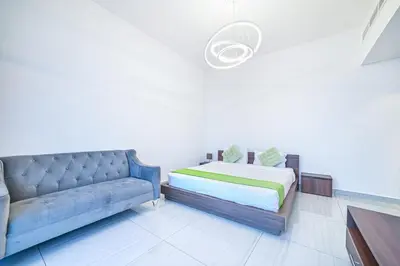 a living room with a couch and a bed at Balcony Breeze O2 with amazing high way view in Dubai