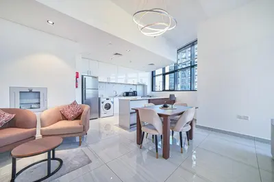 a kitchen and living room with a table and chairs at Balcony Breeze O2 with amazing high way view in Dubai