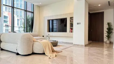 a living room with a couch and a tv at Huge Luxury Waterfront Duplex in Peninsula 5 in Dubai