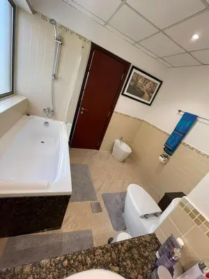 a bathroom with a tub and a toilet and a sink at Two Bedroom Apartment with Excellent Location in Dubai