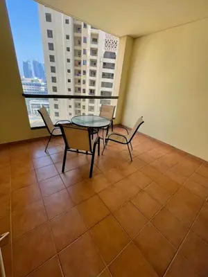 a table and chairs in a room with a window at Two Bedroom Apartment with Excellent Location in Dubai