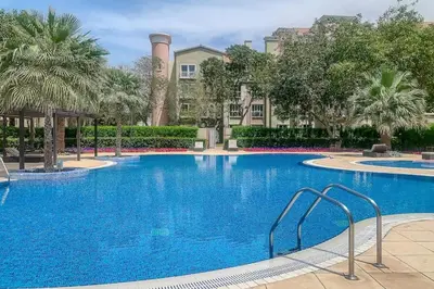 a large blue swimming pool with palm trees and buildings at Airstay - Upgraded Studio - Near Pool & Metro - Monthly Offer Available! in Dubai