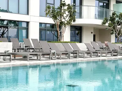 a row of lounge chairs next to a swimming pool at Sea View Apartment at Emaar Beachfront by KeyRock in Dubai