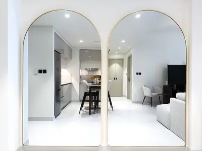a kitchen and living room with a large mirror at Sea View Apartment at Emaar Beachfront by KeyRock in Dubai