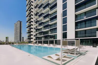 a swimming pool in front of a tall building at GuestReady- Comfortable 1 bedroom- High Floor in Dubai