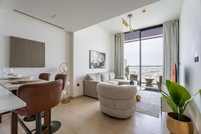 a living room with a table and a living room with a couch at GuestReady- Comfortable 1 bedroom- High Floor in Dubai