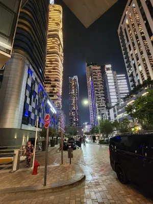 a city street at night with tall buildings at Damac Maison Mall Street LARGE 2BR I Full Burj Views I Connects Dubai Mall in Dubai