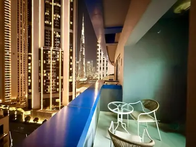 a room with two chairs and a table and a city skyline at Damac Maison Mall Street LARGE 2BR I Full Burj Views I Connects Dubai Mall in Dubai