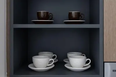 a shelf with cups and saucers on it at Stylish 1BR, Walk to Burj Khalifa and Dubai Mall in Dubai