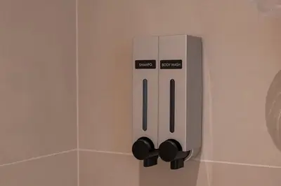 a soap dispenser on a wall in a bathroom at Stylish 1BR, Walk to Burj Khalifa and Dubai Mall in Dubai