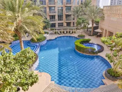 an overhead view of a large swimming pool with palm trees at Dream Shoma-2BR - Pool - Walk to Burj Khalifa in Dubai
