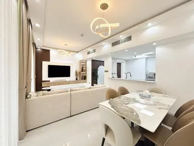a living room with a dining table and a tv at Dream Shoma-2BR - Pool - Walk to Burj Khalifa in Dubai