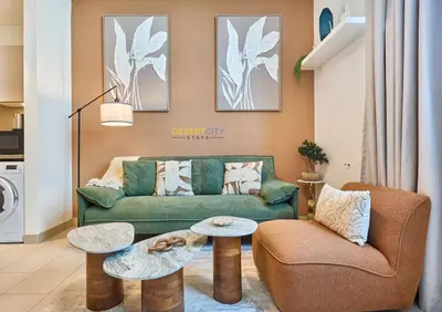 a living room with a green couch and two tables at Stylish and Sophisticated Home Near Downtown Dubai Hosted by Desert City Stays in Dubai