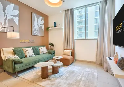 a living room with a green couch and a table at Stylish and Sophisticated Home Near Downtown Dubai Hosted by Desert City Stays in Dubai
