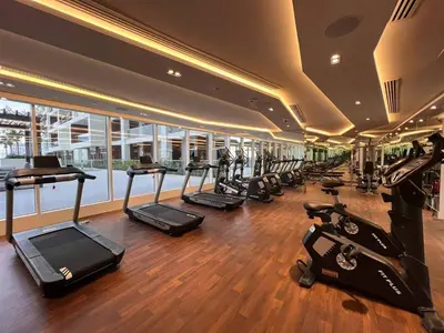 a gym with a row of treadmills and ellipticals at Fully Equipped Home near Miracle & Butterfly Gardens in Dubai