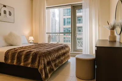 a bedroom with a bed and a large window at Burj Khalifa 1BR Pool Gym Sauna Dubai Mall in Dubai