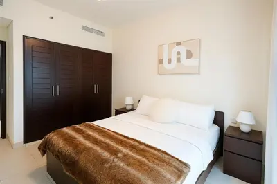 a bedroom with a large bed with a brown blanket at Burj Khalifa 1BR Pool Gym Sauna Dubai Mall in Dubai