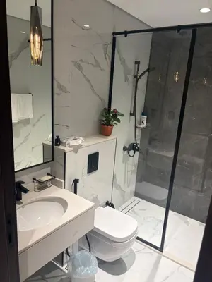 a bathroom with a toilet and a sink and a shower at Modern Downtown 1BR Apartment in jumeirah Garden in Dubai