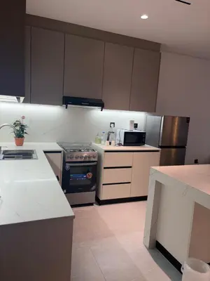 a kitchen with white cabinets and a stove top oven at Modern Downtown 1BR Apartment in jumeirah Garden in Dubai