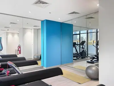 a gym with blue doors and exercise equipment at Chic Studio in Azizi Riviera Minutes to Downtown in Dubai