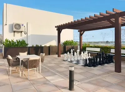 a patio with a chess board and a table and chairs at Chic Studio in Azizi Riviera Minutes to Downtown in Dubai