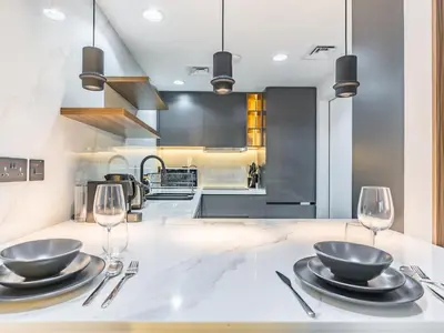 a kitchen with two bowls and wine glasses on a counter at Waterfront 1BR- Time Place Dubai Marina-City Views in Dubai