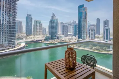 a tea kettle on a table on a balcony with a view of a city at GuestReady - 1BR I Marina Walk - Canal View in Dubai