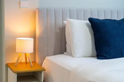 a bed with a blue pillow and a lamp on a table at GuestReady - 1BR I Marina Walk - Canal View in Dubai