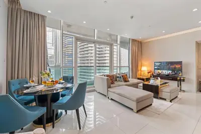 a living room with a couch and a table and chairs at Nice 2 Bedroom DAMAC Uppercrest Downtown Near Dubai Mall - Partial Burj Khalifa View in Dubai
