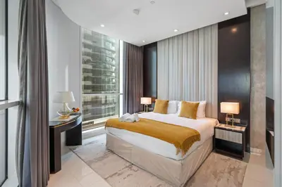 a bedroom with a large bed and a large window at Nice 2 Bedroom DAMAC Uppercrest Downtown Near Dubai Mall - Partial Burj Khalifa View in Dubai