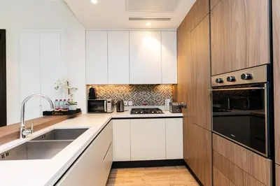 a kitchen with white cabinets and a sink at CitiHome Refined 1BR Jumeirah Living Marina Gate in Dubai