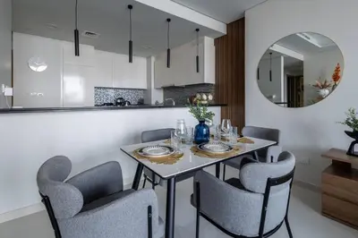 a dining room with a table with chairs and a mirror at Top Amenities, Luxury 2BR, 5 min. to Burj Khalifa in Dubai
