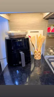 a microwave sitting on a counter with wooden utensils at Ruby home in Dubai